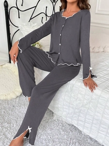 Detail showing white lettuce trim on dark grey pajamas and side slit trouser hems