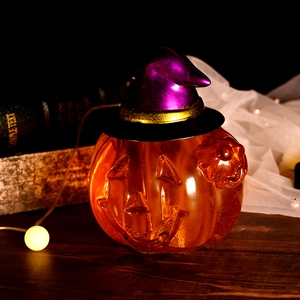 Lanterne citrouille d'Halloween avec chapeau de sorcier violet sur table en bois