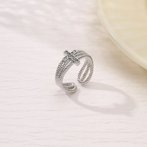 Detailed close-up of a silver twisted multi-layer ring with a sparkling cross emblem