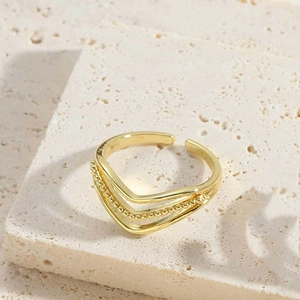 Detail of 14K gold plated V-shaped triple layer star ring on beige stone background