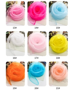 Dettaglio di foulard quadrati in chiffon tinta unita in nove colori vivaci piegati a rosa