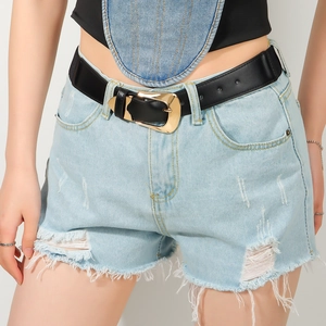 Detail of a black leather belt with a golden D-ring buckle on light blue denim shorts