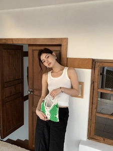 Detail view of handmade crochet tote bag in green and white knit with diamond pattern