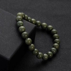 Macro detail of natural dark green jade beads bracelet on elegant black display stand