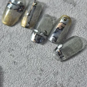 Macro shot of 3D metallic marble nail stickers with dark industrial art and silver rivets