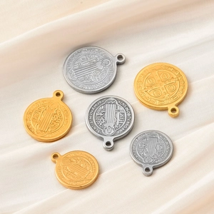 Macro shot of gold and silver Saint Benedict medals on elegant cream silk fabric
