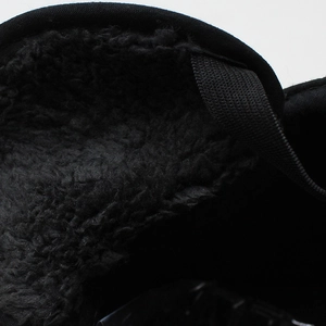 Makro-Detail des warmen schwarzen Fleece-Futters und der strukturierten Innenseite des Winterhutes