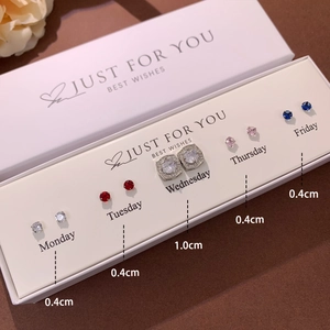 Detail view of five pairs of heart and crystal stud earrings on a weekday display card