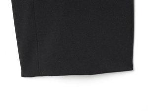 Detailed stitching and fabric texture on black padded shoulder blazer hem and cuff