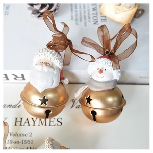 Detail of Christmas tree ornaments featuring resin figures and golden metal bells