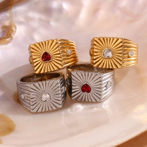 Macro view of gold and silver signet rings with heart stones on a decorative seashell