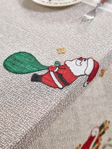 Detailed close-up of Santa Claus embroidery on a woven linen Christmas tablecloth