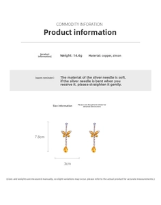 Macro detail of long butterfly drop earrings with orange zircon and copper finish