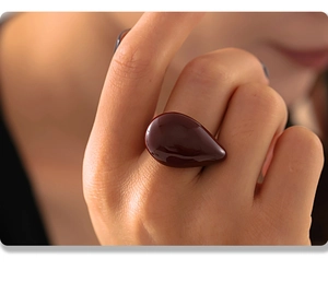 Eleganter Tropfenring in Weinrot mit poliertem 18K vergoldetem PVD-Finish am Finger