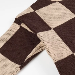 Close-up of checkerboard pattern sweater showing brown and beige knit texture detail