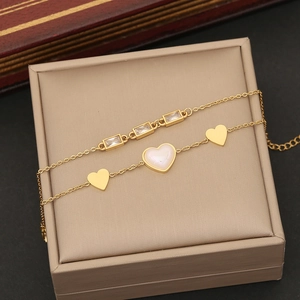 Macro detail of gold double-layer necklace with pearl heart and zircon pendants