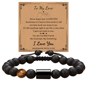 Detail of beaded men's bracelet with black matte stones and tiger eye on greeting card