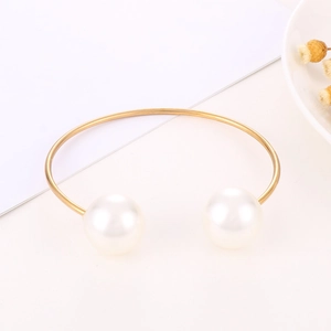 Detailaufnahme des 18k vergoldeten Armreifs mit zwei eleganten großen weißen Perlen