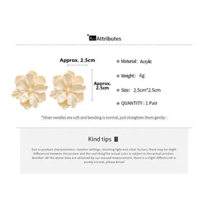 Vue détaillée des boucles d'oreilles fleurs en acrylique crème avec dimensions de 2,5 cm