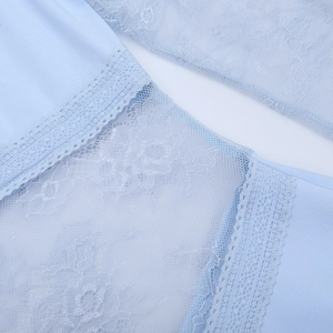 Gros plan sur la dentelle florale bleu clair et la texture en tricot d'une robe