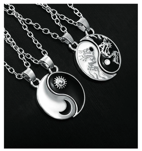 Detailed view of silver Tai Chi Yin Yang pendants with sun and dragon pattern necklaces