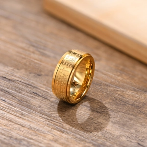 Detail of golden spinner ring with engraved cross and Lord's Prayer on wood