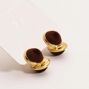 Close-up of 18K gold-plated studs featuring elegant dark brown flocked velvet spheres