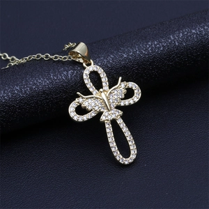 Close-up of gold butterfly pendant featuring micro-pave zircons on black leather background