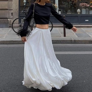 Detail of white satin maxi skirt with high-shine texture and sleek silhouette design