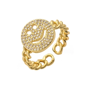 Macro detail of gold-plated smiley face ring with pavé zircons and Cuban chain band