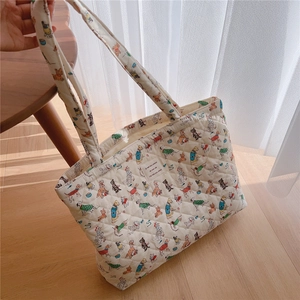 Close-up of quilted cotton tote bag with colorful cartoon dog patterns and fabric label