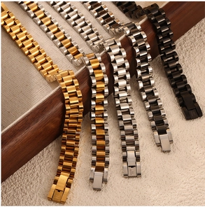 Detail view of multi-color stainless steel watch bands with triple link design in a wood tray
