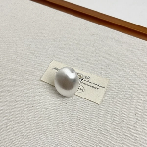 Macro shot of silver brushed metal ring on textured fabric with a minimalist aesthetic
