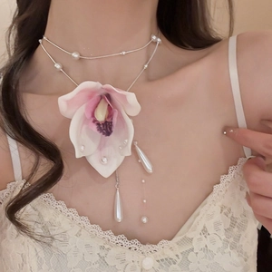 Close-up of fabric mesh orchid necklace with multi-layer silver chains and pearl tassels