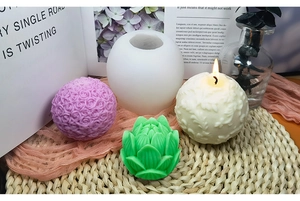 Detalle de moldes de silicona de rosa y loto con velas DIY y una mecha encendida