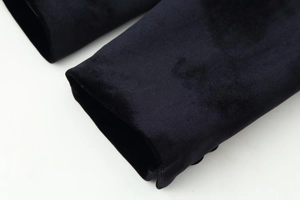 Vue détaillée des poignets en velours noir montrant la texture du tissu luxueux