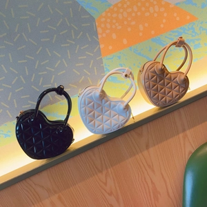 Three heart-shaped PVC jelly bags in black, white, and beige with quilted geometric patterns
