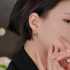 Exquisite emerald cut green zircon earrings in silver setting worn by a female model