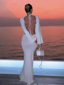 Elegant backless knitted maxi dress in cream white featuring long sleeves for beach vacations