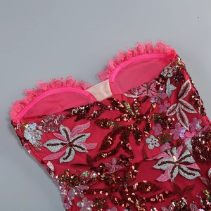 Detail of rose red lace fabric with sequins and floral embroidery on the dress
