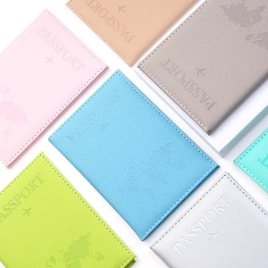 Close-up of matte PU leather passport covers with embossed world map and airplane logo