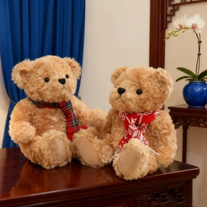 Plush brown teddy bears with stylish plaid scarves sitting in a cozy home setting