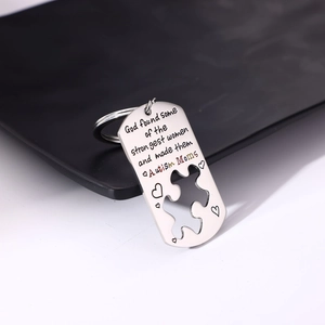 Macro shot of silver stainless steel keychain with heart and puzzle cutout for Autism Moms