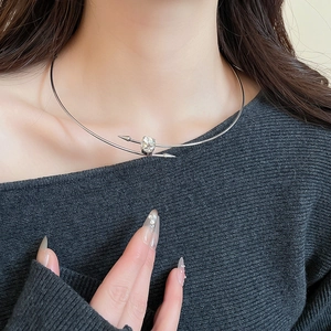 Close-up of silver minimalist choker with oval crystal and overlapping arrow design
