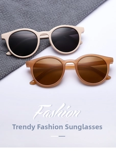 Detail of retro round sunglasses in cream and amber shades on textured fabric background