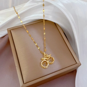 Exquisite gold cherry pendant necklace with shimmering cubic zirconia on white silk