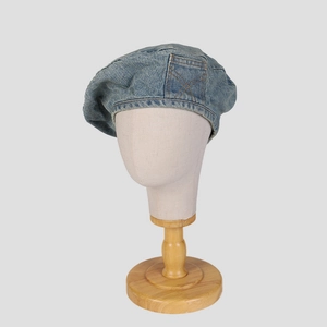 Retro washed denim beret for women with side pocket detail on a display stand