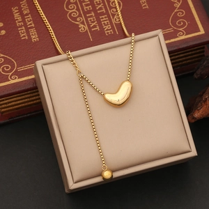 Detailed close-up of golden heart pendant necklace with beads on vintage jewelry box