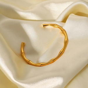 Vue détaillée du bracelet jonc style bambou doré sur fond de soie douce et luxueux