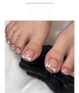 French white toe press-on nails with black polka dots and cartoon character detail
